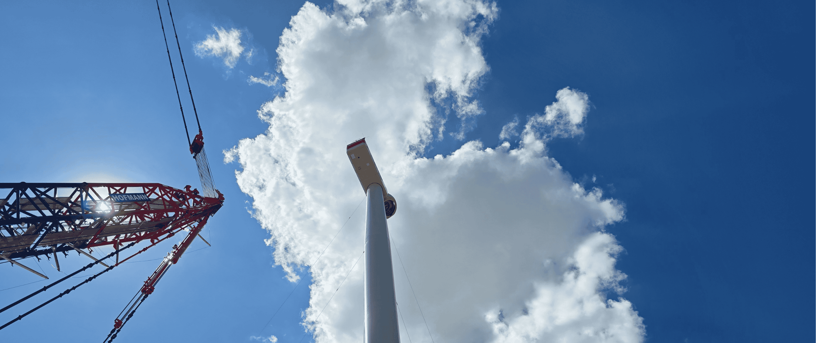 Ein Kran neben einer Windkraftanlage